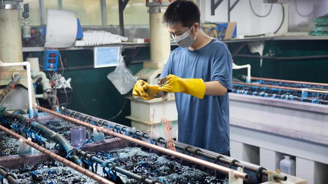 Operator handling jewelry components at an electroplating line